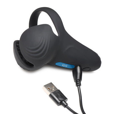 Black silicone vibrating cock ring with taint stimulator and USB charging cable on white background.
