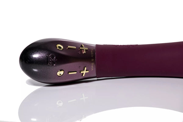 Close-up of plum-colored Hot Octopuss Kurve G-spot vibrator with gold control buttons on a reflective surface.
