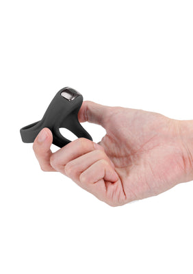 Hand holding a black Renegade Emperor rechargeable vibrating ring with ergonomic design and control button.