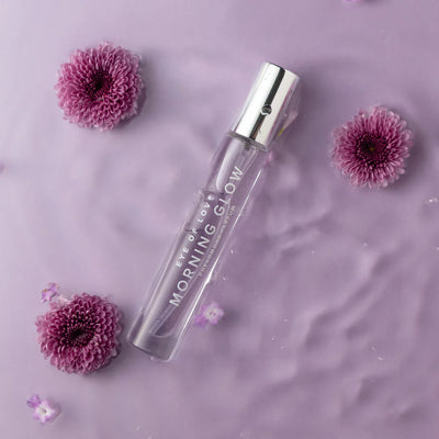 Eye of Love Morning Glow pheromone perfume bottle on soft purple background with pink flowers.