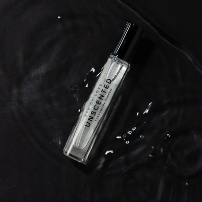 Eye of Love unscented pheromone perfume for men in a clear glass spray bottle on a dark textured surface.