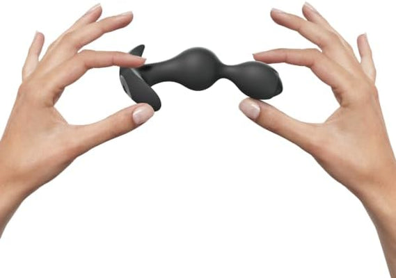 Hands holding the black Love to Love Twinny Bud anal stimulator with two connected rounded pearls.