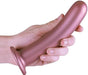 Hand holding a smooth rose gold silicone G-spot dildo with a strong suction base.