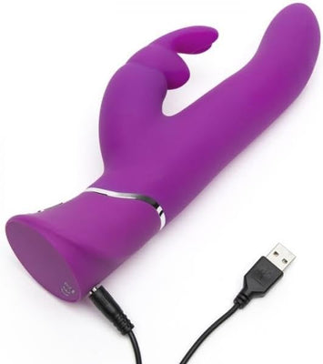 Purple silicone rabbit vibrator with curved shaft and USB charging cable attached on white background
