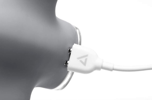 Close-up of magenta Clandestine Devices Mimic Plus vibrator connected to a white magnetic USB charging cable.