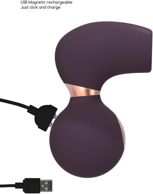 Purple ergonomic clitoral vibrator with USB magnetic rechargeable charging cable attached.