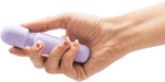 Hand holding a compact lavender Emojibator Tiny Wand vibrator with textured grip and rounded head.