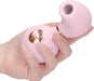 Hand holding a pink, ergonomic clitoral vibrator with a rose gold control button and soft silicone finish.