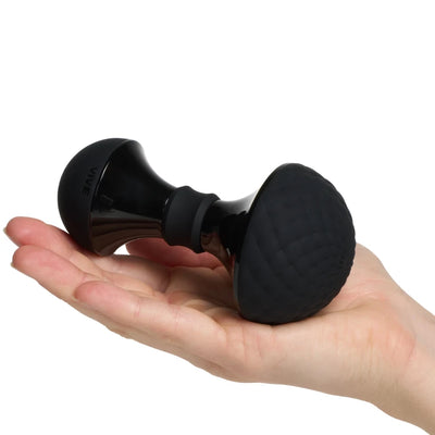 Compact black Vive Enoki bendable massager with textured silicone head held in hand for size reference.