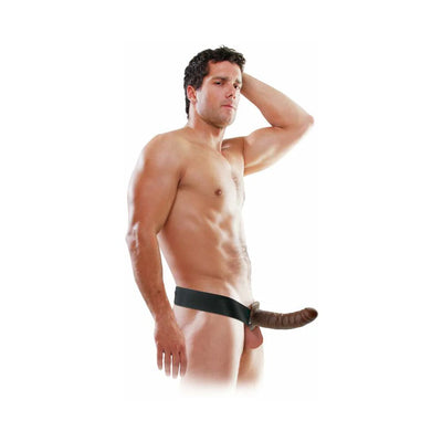 Muscular man wearing an 8-inch hollow strap-on with adjustable black harness against a white background.