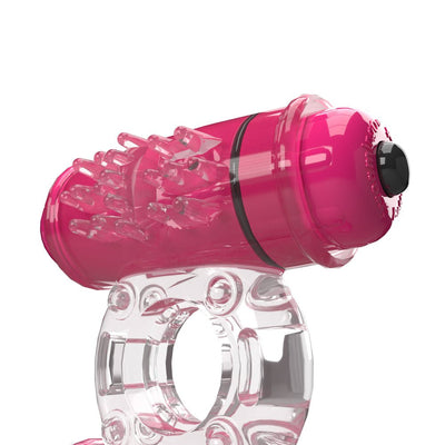 Transparent and pink vibrating ring with textured nodules and a button on top for control.