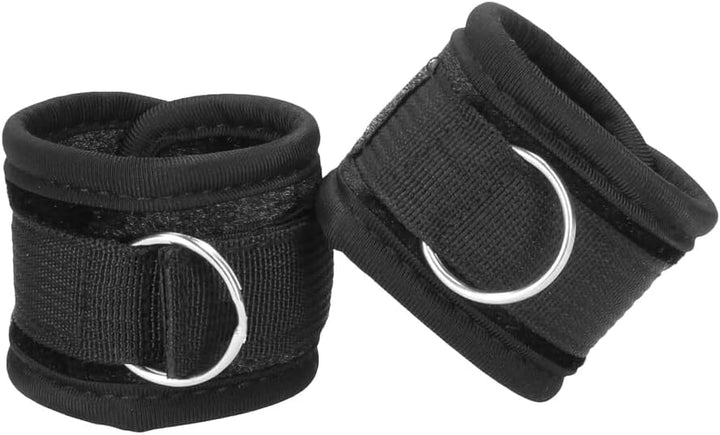 Pair of black velvet and velcro adjustable handcuffs with metal D-rings for secure restraint.
