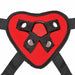 Red heart-shaped strap on harness with black adjustable straps and metal snap fasteners.