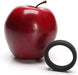 Black soft silicone c-ring displayed next to a red apple for size comparison on a white background.