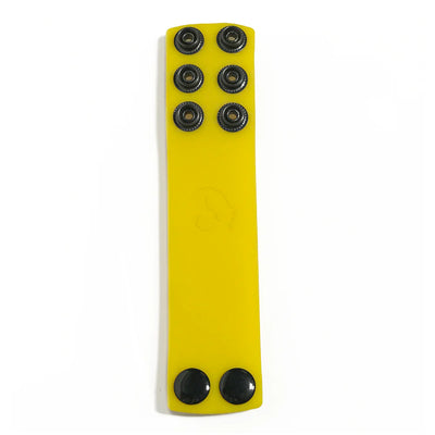 Yellow silicone ball strap stretcher with multiple black snap fasteners for adjustable sizing.