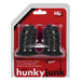 Hunkyjunk Elong wide base black nipsuckers in clear plastic packaging on red backing card.