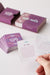 The Naughty and Nice Dates Kit with purple-themed cards, one card held up featuring a playful date idea.