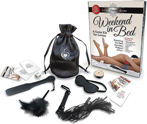 Weekend In Bed Game Kit with cards, dice, feather tickler, blindfold, paddle, flogger, massage candle, and storage bag displayed.