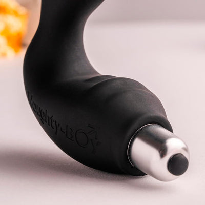 Close-up of the black Naughty-Boy prostate stimulator with a smooth, curved design and removable silver vibration bullet.