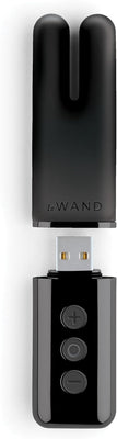 Black Le Wand Deux mini vibrator with dual-ended design and USB charging base featuring control buttons.