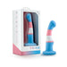 Blue, pink, and white silicone dong with curved design and suction base, displayed next to its Pride by Avant packaging.