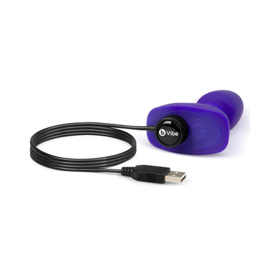 Purple B-Vibe Rimming Petite Plug with USB charging cable on white background.