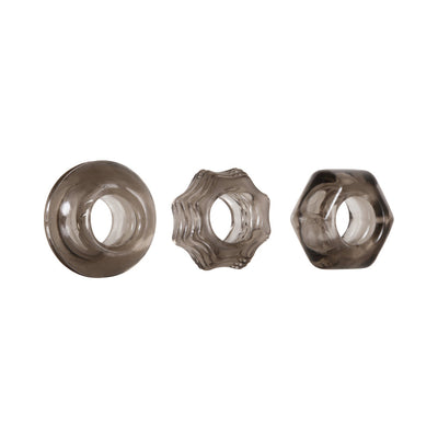 Set of three smoke-colored thick cock rings in circle, star, and hexagon shapes with textured designs.