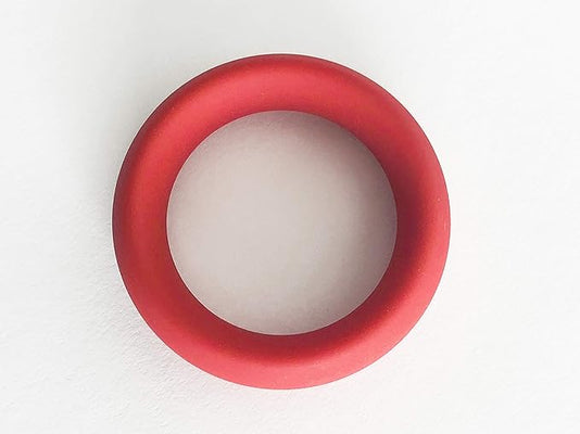 Red flexible cock ring with smooth finish displayed on a white background.