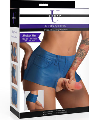 Packaging of Strap U Booty Shorts medium size with blue silicone shorts and attached realistic dildo harness shown on model.