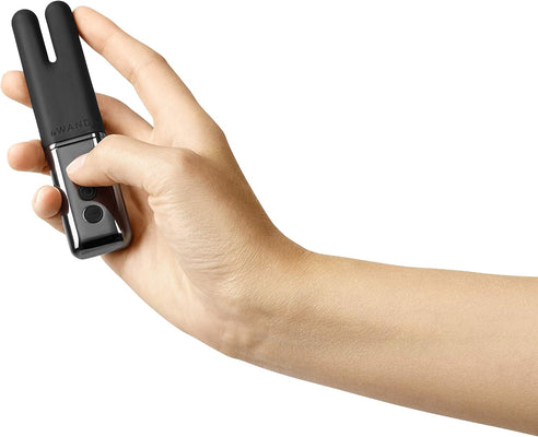 Hand holding the black Le Wand Deux dual-ended mini vibrator with control buttons visible.