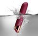Chaiamo Burgundy waterproof vibrator with smooth silicone body and rose gold accent submerged in water with splash effect.