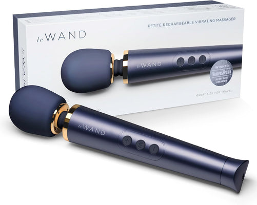 Le Wand Petite rechargeable vibrating massager in dark blue with gold accents displayed with its packaging box.