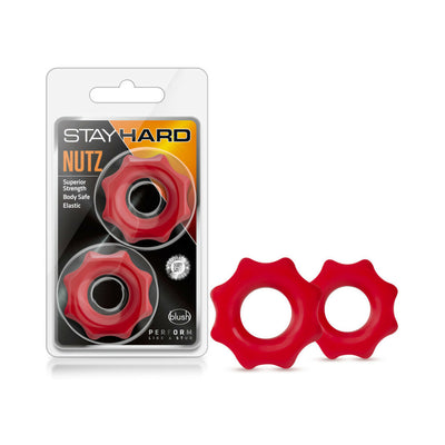 Two red Stay Hard Nutz cock rings with wavy edges, shown in and out of clear retail packaging.