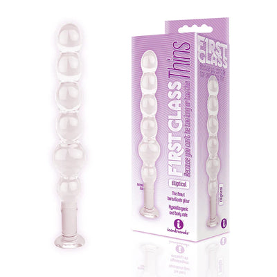 Clear elliptical glass plug with graduated bulb design next to purple First Glass Thins product packaging.