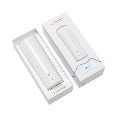 Lovense Max 2 male masturbator in white with ribbed texture shown in open box next to product packaging.