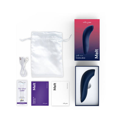 We-Vibe Melt clitoral stimulator in navy with packaging, USB charging cable, satin storage pouch, lubricant sample, and user guides.
