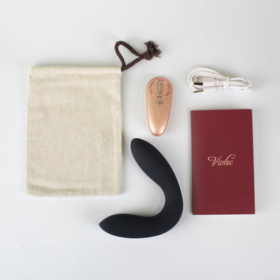 Hercules Remote C-shape Vibrating Plug with rose gold remote, USB charging cable, storage pouch, and instruction booklet on white background.
