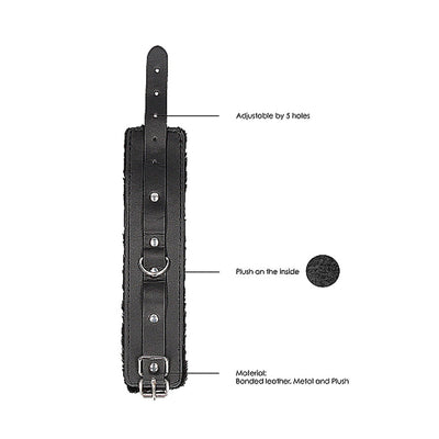 Black and white bonded leather hand cuff with plush lining, adjustable strap, metal buckle, and D-ring detail.