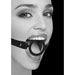 Close-up of a woman wearing a black and white silicone ring gag with an adjustable leather strap.