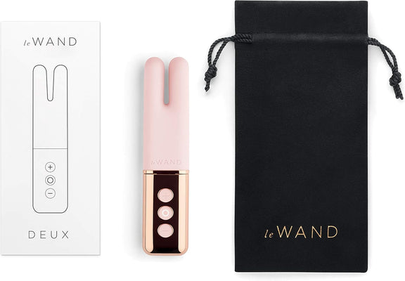 Le Wand Deux dual-ended mini vibrator in pink with rose gold accents, packaging box, and black drawstring storage pouch.