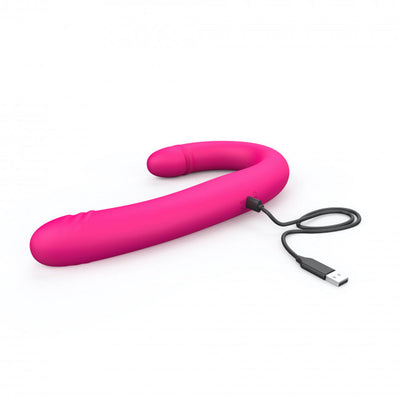Pink flexible double-ended vibrator with USB charging cable on white background.