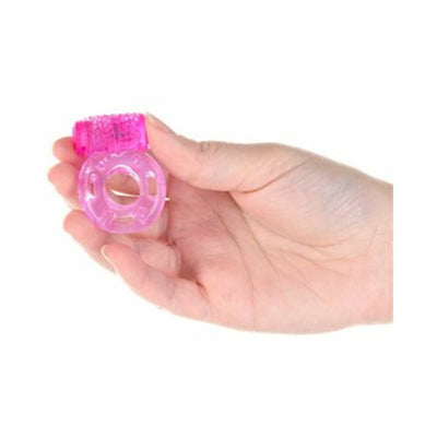 Hand holding a pink silicone vibrating cockring with textured butterfly design and removable motor.