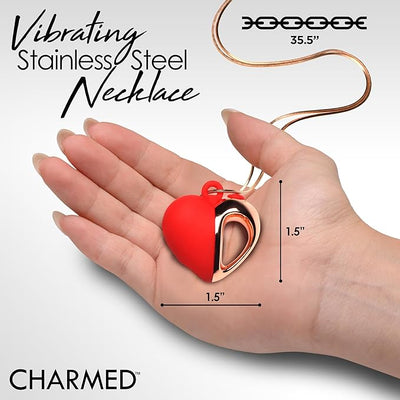 Hand holding a red and rose gold heart-shaped vibrating necklace with a 35.5-inch stainless steel chain.