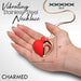 Hand holding a red and rose gold heart-shaped vibrating necklace with a 35.5-inch stainless steel chain.