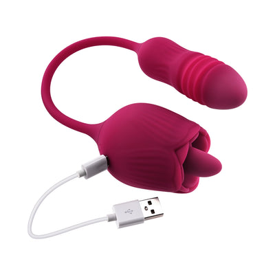 Red dual-ended silicone pleasure toy with flexible connector and USB magnetic charging cable attached.
