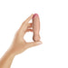 Hand holding a small, realistic vibrating bullet dildo in natural skin tone with pink tip against white background.