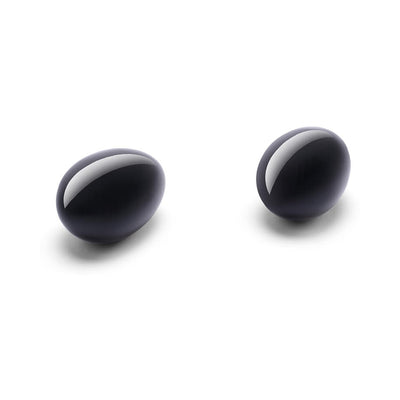Two polished black obsidian crystal eggs on a white background, designed for pelvic floor wellness.