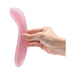 Hand holding a curved rose quartz crystal G-spot wand with a smooth, polished surface.