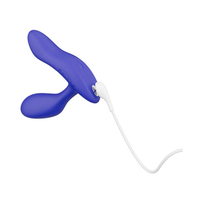 Blue We-Vibe Vector+ adjustable prostate massager with USB charging cable attached on white background.