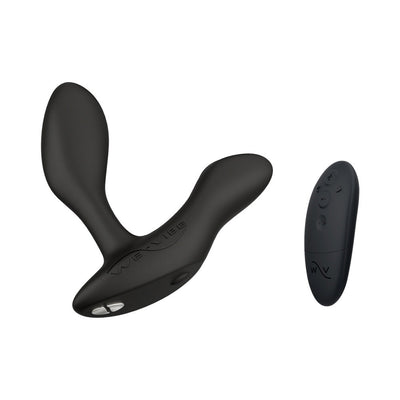 Black We-Vibe Vector+ adjustable prostate massager with dual motors and matching remote control on white background.
